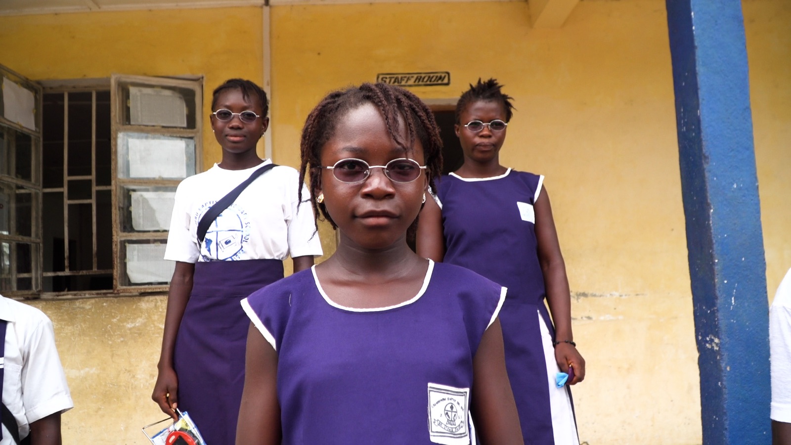 Three schoolgirls in uniform wearing prescription glasses